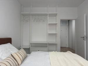 ein Schlafzimmer mit einem weißen Bett und weißen Regalen in der Unterkunft Dvojizbový apartmán v centre in Poprad + 16 Fotos