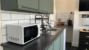 a kitchen with a microwave on a counter at Self-contained Room within shared home in Manchester
