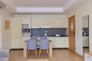 a kitchen with a table and two blue chairs at Legit Luxury Apartment at Aiport Accra in Accra
