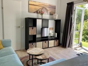 una sala de estar con un sofá y una mesa en Holiday home with terrace, en Sint Maartenszee