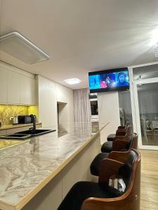 a kitchen with a bar with chairs and a flat screen tv at Best view from center of Yerevan in Yerevan