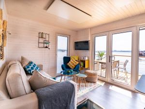 a living room with a couch and chairs and a table at Hausboot Schatzkiste in Fehmarn