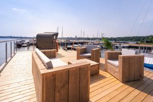 a wooden deck with chairs and a grill on a boat at Hausboot Schatzkiste in Fehmarn