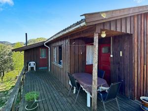 a cabin with a table and chairs on a deck at 5 person holiday home in FARSUND-By Traum in Helle