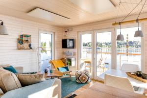 a living room with a couch and a table at Hausboot TreibGut in Fehmarn