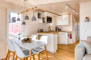 a kitchen and dining room with a white table and chairs at Hausboot TreibGut in Fehmarn
