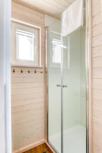 a walk in shower in a bathroom with wooden walls at Hausboot TreibGut in Fehmarn +18 photos