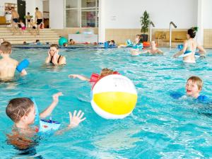 a group of children playing with a beach ball in a swimming pool at 8 person holiday home on a holiday park in Gråsten in Gråsten