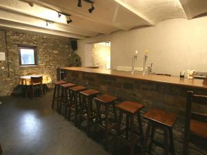 a bar with wooden stools and a counter in a restaurant at Grand Family Farmhouse in Anthisnes in Anthisnes +32 photos
