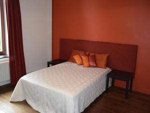 a bedroom with a white bed with orange walls at Grand Family Farmhouse in Anthisnes in Anthisnes