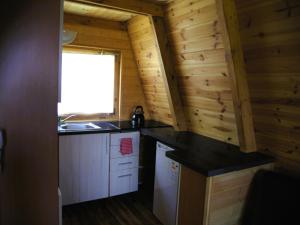a kitchen in a log cabin with a sink and a window at Summer house for 4 people, close to the sea in Łazy