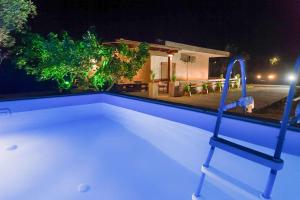 una piscina por la noche con una silla junto a ella en Sinani Villa - Garden Oasis with Private Pool, en Kolymbia