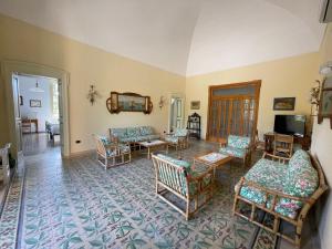 a living room with couches and chairs and a television at Villa Del Prete in Nardò