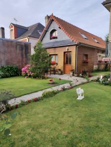 una casa con un cane bianco nel cortile di Maison à Saint-Blimont a Saint-Blimont