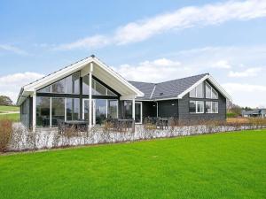 a house with a green lawn in front of it at 18 person holiday home in Faaborg in Fåborg