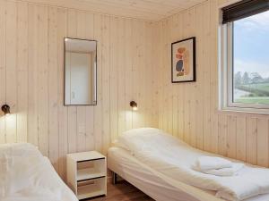 a bedroom with two beds and a mirror and a window at 5 star holiday home in Faaborg in Faaborg
