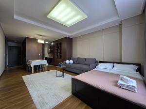 a bedroom with a large bed and a couch at 206 Luxury Апартаменты с шикарным видом на Мечеть Хазрет Султан,2х комн с 2-мя кроватями и раскладным диваном,2 санузла in Astana