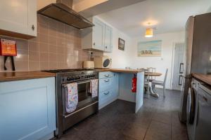 una cocina con estufa y encimera en Beachside Bliss!, en Pakefield