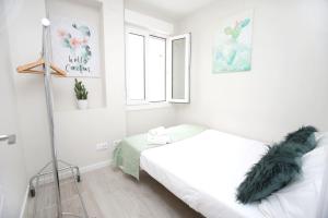 a white bedroom with a bed and a window at El Rincon de la Merced Terraza Aire acondicionado in Almazán