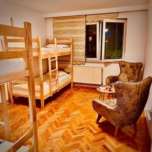 a room with two bunk beds and a chair at Center House Hostel v2 in Pristina