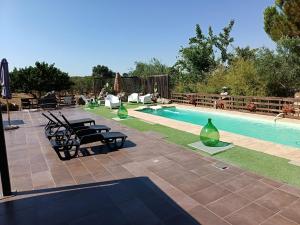 a swimming pool with chairs and vases next to at Borgo Incanto in Acquaviva delle Fonti