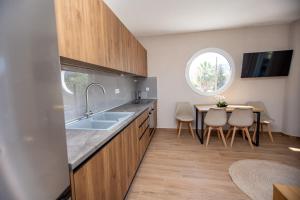 Una cocina con fregadero y una mesa con sillas. en Elea Home, en Nea Vrasna