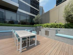 una mesa blanca y sillas en una terraza con parrilla en Shukr شكر - Luxury 3BR with Panoramic Burj Khalifa & Fountain Views - Address Residence Dubai Opera - 2 Min Walk to Dubai Mall, en Dubái