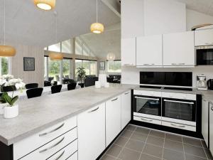a kitchen with white cabinets and a living room at Luxury Pool Retreat in Blavand - By Traum Ferienwohnungen in Blåvand +27 photos