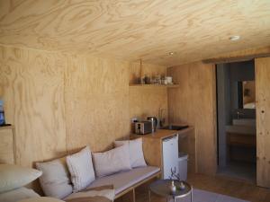 a living room with a couch and a kitchen at Bastu Bicheno Tiny home in Bicheno