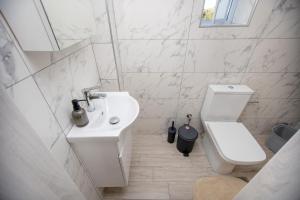 Un baño blanco con lavabo e inodoro. en Elea Home, en Nea Vrasna 148 fotos más