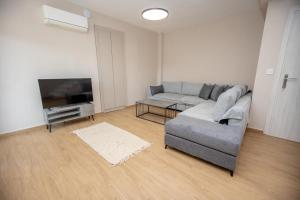 una sala de estar con un sofá y un televisor en Elea Home, en Nea Vrasna