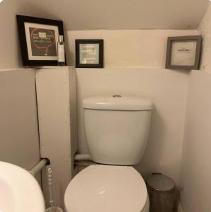a bathroom with a toilet with two pictures on the wall at Northmill Cottage - Charming 2 bed residential property with courtyard in Midhurst +15 photos