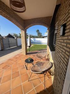 an outdoor patio with two chairs and a table at Sunset Palm in El Puerto de Santa María
