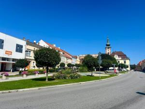 an empty street in a town with a clock tower at Dům na náměstí in Nová Bystřice
