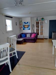 a living room with a purple couch and a table at World House Wetten in Kevelaer