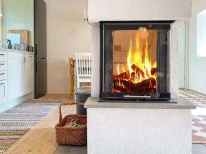 a fireplace in a living room with a fire in it at 4 person holiday home in SKURUP in Skurup +17 photos