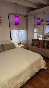 a bedroom with a large white bed with purple lights at Aires de campo en la ciudad in San Fernando del Valle de Catamarca