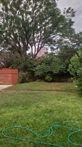 a garden with a hose laying on the grass at Aires de campo en la ciudad in San Fernando del Valle de Catamarca