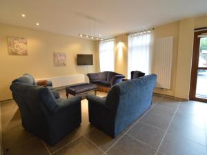 a living room with two couches and a tv at Glabbeek Family Retreat Home in Bunsbeek