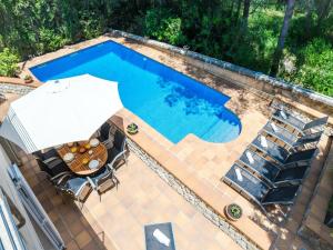 an overhead view of a swimming pool with a table and an umbrella at Villa in Alcúdia near Sandy Beach in Alcudia