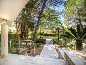 a walkway through a park with trees and a bridge at Villa in Alcúdia near Sandy Beach in Alcudia