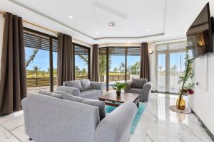 a living room with two couches and a table at Grand Lémuria by First Grand Stays - Luxury 3BR Villa with Private Pool in Bel Ombre