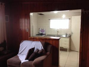cocina con sofá y lavabo en una habitación en Casa Modesta, en Campos do Jordão