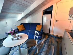 Una sala de estar con un sofá azul y una mesa. en Mansarda Oblique, en Maiori 9 fotos más