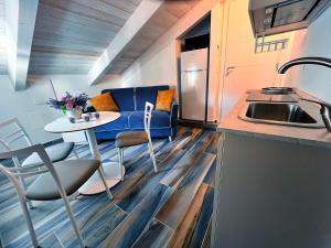 Una pequeña cocina con un sofá azul y una mesa. en Mansarda Oblique, en Maiori