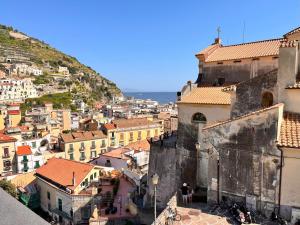 Una vista de una ciudad con edificios y el océano. en Mansarda Oblique, en Maiori
