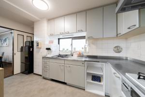 a kitchen with white cabinets and a sink at HOTEL CtrlD ASAGAYA Spacious 130 Square Meter Apartment 4 Bedrooms 7 Beds 3 Minute Walk from JR Asagaya Station in Tokyo