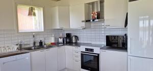 a white kitchen with white cabinets and appliances at Lakeview Houses Sweden in Falun +67 photos