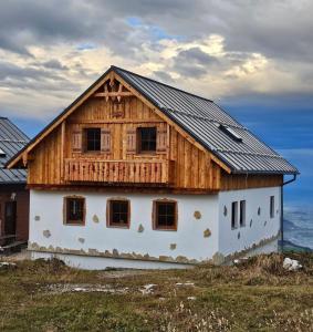 a house with a wooden roof on top of a field at Erlakogelhütte am Feuerkogel in Oberlangbath
