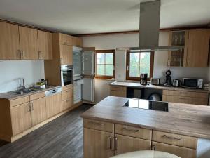 a large kitchen with wooden cabinets and a counter top at Erlakogelhütte am Feuerkogel in Oberlangbath